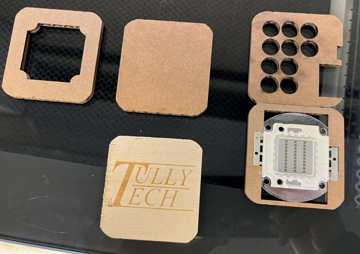 Laser-cut MDF plates for the second prototype on the laser bed, Tully Tech engraved