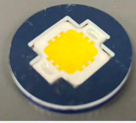The first prototype: a navy laser-cut disc with the white COB module seated in a cross-shaped cutout